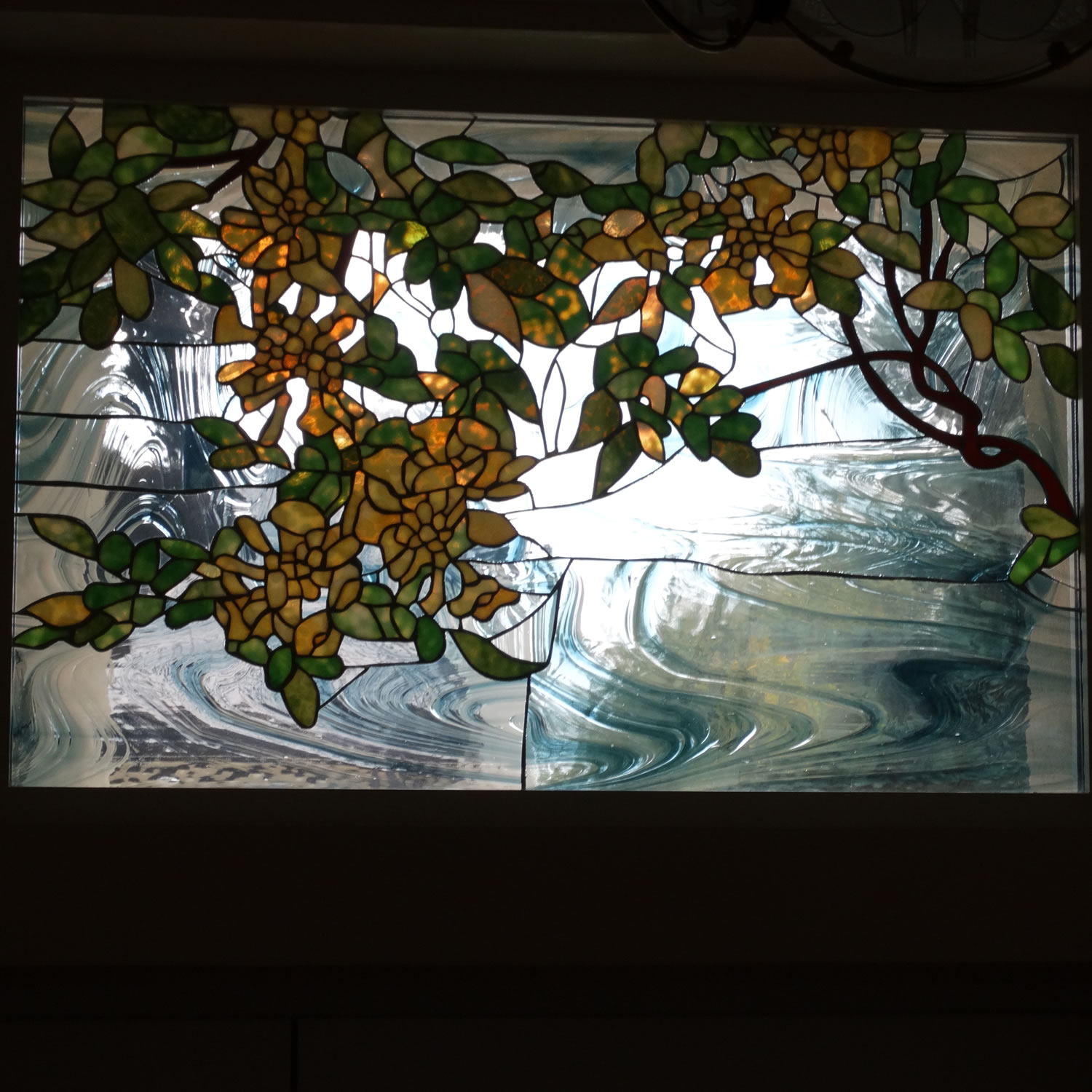 Witraż z motywem roślinnym wykonany w oknie lukarnowym.