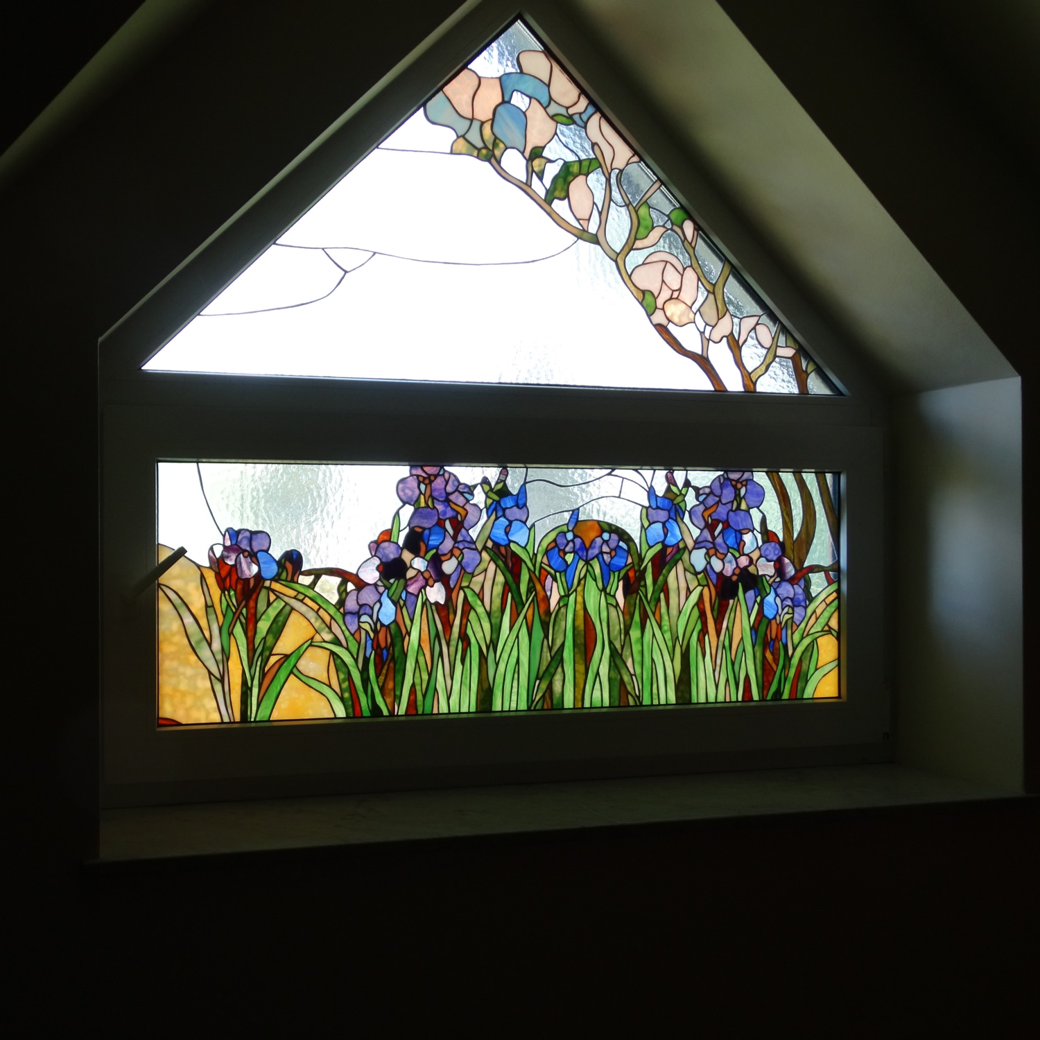Witraż z motywem roślinnym wykonany w oknie lukarnowym.